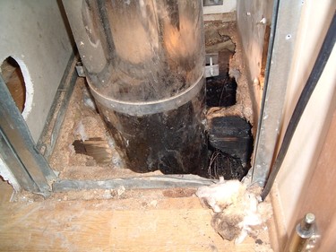 Obrázek 7 – Vícevrstvý kovový komín vedený dřevěnou stropní konstrukcí. Plášť komína se těsně dotýká dřevěných trámků. Při odvodu spalin z krbu došlo k požáru.