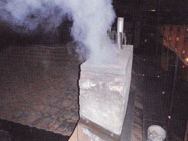 Obr. 2a. Zplodiny s kouřem vystupující z komína při jeho hašení pískem [3]