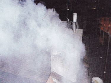 Obr. 2b. Zplodiny s kouřem vystupující z komína při jeho hašení pískem [3]