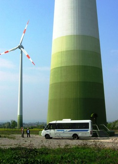 Větrná elektrárna Enercon E-112 s výkonem 4,5 MW (obec Egeln u Magdeburgu) a porovnání velikosti spodního železobetonového dílu věže s autobusem. (Foto B. Koč)