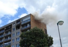 Obr. 5 Požár BD v Čelákovicích, 2007; a) vývin hustého dýmu z požáru střešního pláště (P. Mikulka)