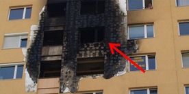 Obr. 7 Požár BD v Miskolći, 2009; poškození kontaktního zateplovacího systému. Šipka ukazuje místo vzniku požáru (M. Hajpál)
