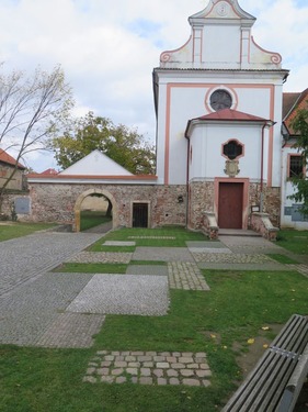 Pro zpevnění prostranství před kaplí v Dobřichovicích jsou použity dva druhy dlažby v kombinaci s trávníkem