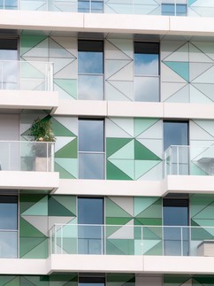 Bytový dům ve Francii s fasádou, kombinující kontaktní zateplovací systém StoTherm Classic, předsazený provětrávaný zateplovací systém StoVentec Glass, složený ze skleněných panelů různých tvarů a bílý fasádní povrch  StoSignature.