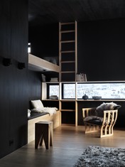 Kontrasty světel, materiálů a barev: Úzká horizontální i vertikální okna přerušují černé dřevěné obložení interiéru.