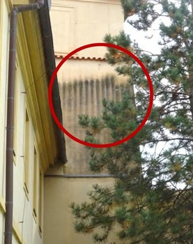 Obr. 9b: Chybějící ukončení hydroizolace v soklové oblasti, zvýšená vlhkost fasády pod římsou. (Okna v různých úrovních jsou důsledkem mnoha historických úprav.)