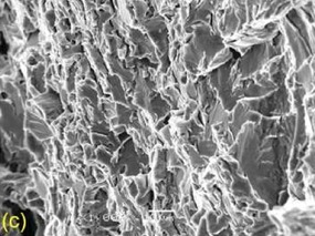 Obr. 3 Vzorek X-60-12: (c) transkrystalický štepný lom, detail