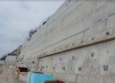 Obr.&nbsp;5a – Poh�ad na z�padn� �as� OM1 (mo�no vidie� nosn�ky s&nbsp;5-lanov�mi kotvami, nosn�ky s&nbsp;19-lanov�mi kotvami, ty�e WR&nbsp;47 osaden� pred l�c m�ru, vylamov�ky pre kvetin��e, odvod�ovacie otvory fi 70&nbsp;mm, v&nbsp;pozad� geodren�na f�lia medzi torkr�tom a �b. stenou)