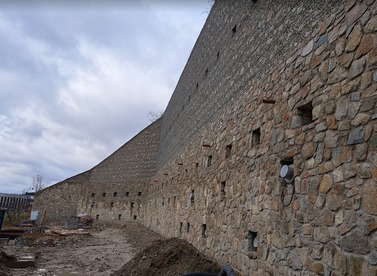 Obr.&nbsp;5b – Poh�ad na z�padn� �as� OM1 (mo�no vidie� nosn�ky s&nbsp;5-lanov�mi kotvami, nosn�ky s&nbsp;19-lanov�mi kotvami, ty�e WR&nbsp;47 osaden� pred l�c m�ru, vylamov�ky pre kvetin��e, odvod�ovacie otvory fi 70&nbsp;mm, v&nbsp;pozad� geodren�na f�lia medzi torkr�tom a �b. stenou)