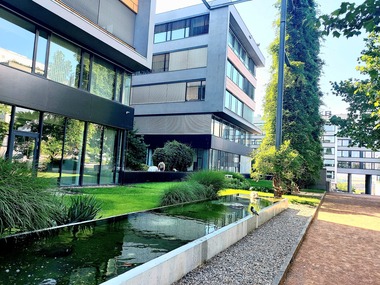 Foto&nbsp;1 Relaxační zóna administrativního komplexu. Vodní zrcadlo a&nbsp;udržovaná zeleň vytvářejí klidový prostor v&nbsp;zadní části areálu. Otevřené průhledy a&nbsp;kvalitní pobytové prvky podporují přehlednost a&nbsp;bezpečné využívání místa.