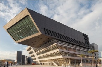 Čtyřpodlažní atrium Library & Learning Center, WU Wien – jeden z&nbsp;nejvýznamnějších projektů v&nbsp;portfoliu DELTA Group. Organické tvary a spirálové rampy, architektka Zaha Hadid. Kampus pro více než 23&nbsp;000&nbsp;studentů. Investice 492&nbsp;mil. EUR. Zdroj: boanet.at